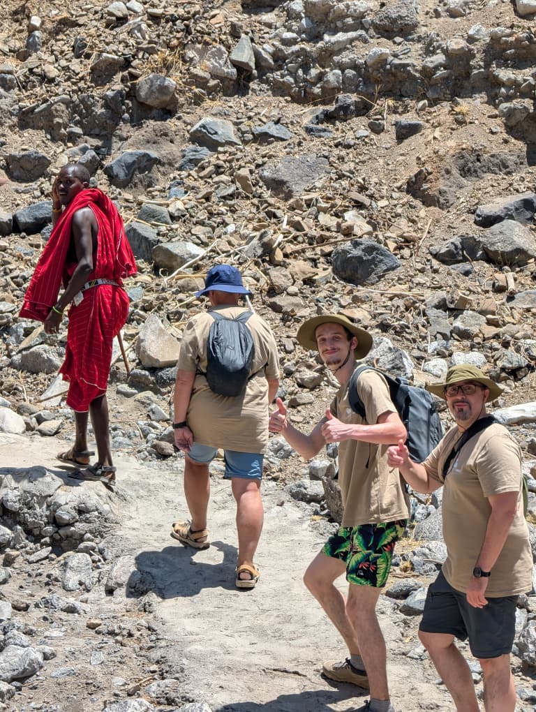 Travellers walking through a rocky highland landscape